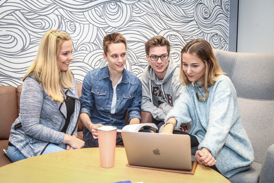 Gruppe mit Laptop in Sesseln Eine Gruppe mit Laptop sitzt auf Sesseln.