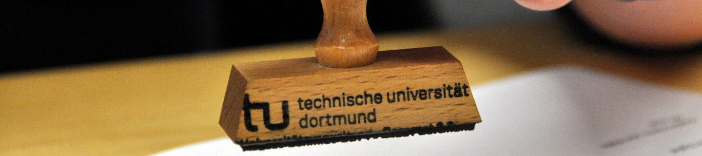 Detail of a hand holding TU Dortmund university stamp