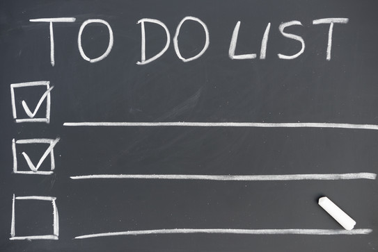 An einer Tafel steht die Überschrift „TO DO LIST”, darunter sind drei Zeilen mit Kästchen an der linken Seite und einem lange Unterstrich. In zwei Kästchen ist ein Haken gesetzt.