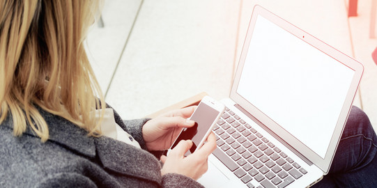 Woman with laptop and smartphone