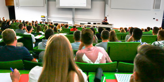 Hörsaal mit Studierenden Studierende sitzen in einer Vorlesung im Hörsaal.