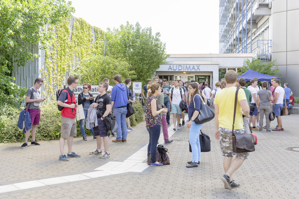 Audimax Studierende stehen vor dem Haupteingang des Audimax.