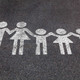 Eine weiße Kreidezeichnung von einer Familie auf dem Boden.