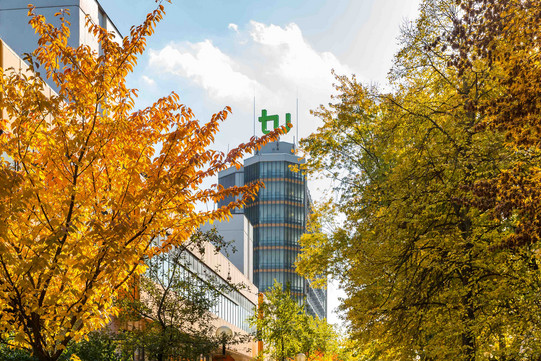 Das Gebäude Mathe-Tower ist von außen zu sehen und links und rechts Bäume in herbstlichen Farben.