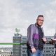 Studierende vor dem Mathetower Zwei Studierende blicken in die Kamera, die Studentin (rechts) hält ein aufgeschlagenes Buch in der Hand, im Hintergrund ist der Mathetower in seiner vollen Länge zu sehen.