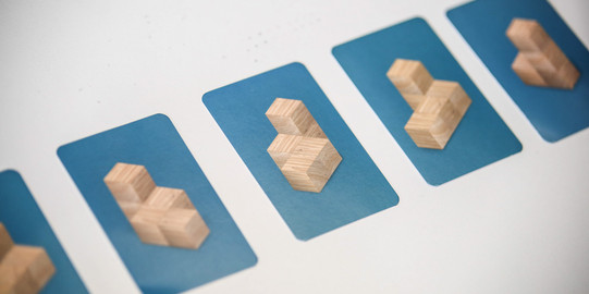 Fünf blaue Kärtchen mit Abbildungen von Holzwürfeln liegen nebeneinander.