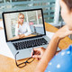 Frau sitzt und hält eine Videokonferenz auf ihrem Laptop mit einer anderen Frau ab