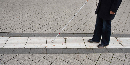 Guidance system for blind people A blind person follows the guidance system for blind people on campus with the help of a blindman's stick.