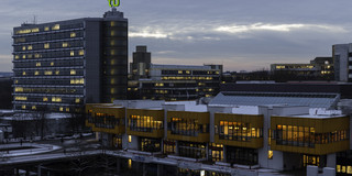 Mehrere mit Schnee bedeckte Gebäude der TU Dortmund in den Abendstunden.