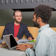 Students in conversational situation Three students sit opposite each other and they are talking.