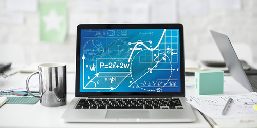 Ein Laptop mit mathematischen Formeln steht auf einem weißen Schreibtisch neben einer Tasse, Stiften und Blättern.