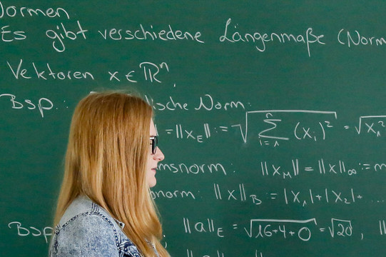 Studierende vor einer Tafel Zwei Studentinnen stehen vor einer Tafel und besprechen sich.