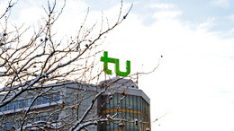 Januar Ein Gebäude mit TU Dortmund Logo und mit Schnee bedeckte Äste.