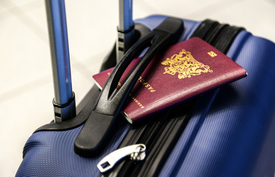 On a blue suitcase is a passport.