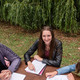 Studierende lernen draußen Drei Studierende sitzen an einem Tisch auf einer Wiese und lernen.