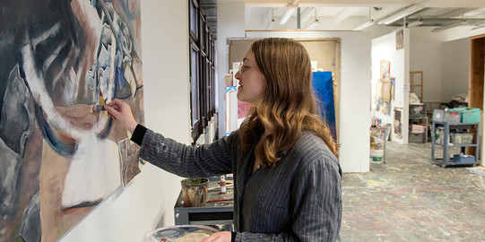 Malerin-Atelier Eine Frau malt ein Bild in einem Atelier.