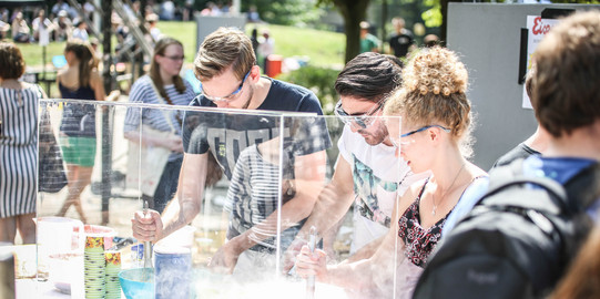 Studierende am Trockeneisstand Studierende mit Schutzbrillen am Trockeneisstand